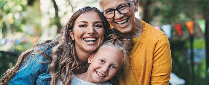 female smiling with daughter and elderly mother