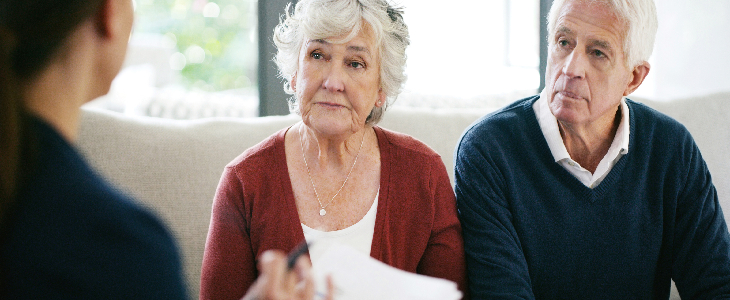 elderly couple speaking with an estate planning attorney