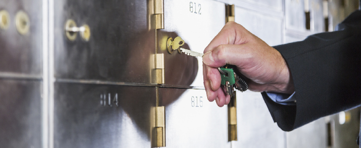 male opening bank safe deposit box to store important documents