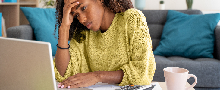 female doing online estate planning and looking stressed in front of a laptop