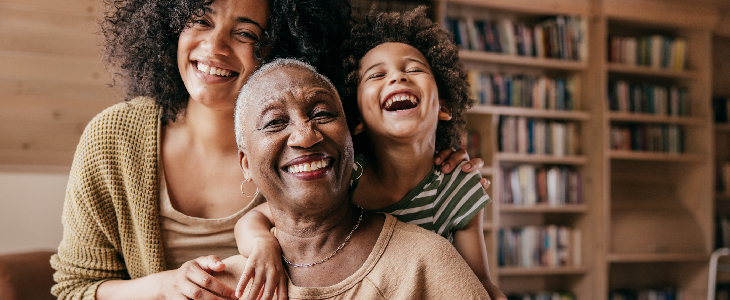 elderly female with grandchildren smiling and thinking about her estate plan